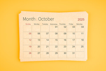 October 2025 calendar from brown recycle paper on yellow background.