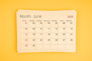 June 2025 calendar from brown recycle paper on yellow background.