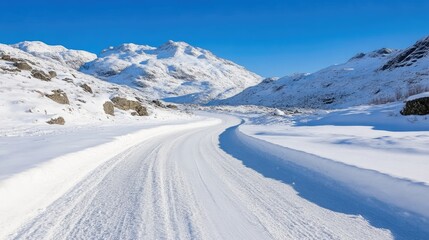 Obraz premium Snowy mountain road winding through a pristine winter landscape