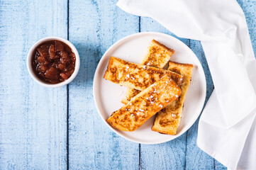 Appetizing croutons in powdered sugar on a plate on the table top view