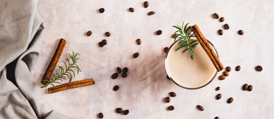 Cup of iced latte with rosemary and cinnamon on the table top view web banner