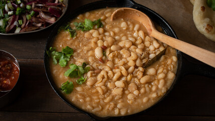 Stewed beans and flat breads served along pickled onion, sauteed onions and salsa