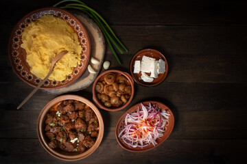 Traditional Eastern European corn mush (mamaliga, polenta, banosh, balmes) served with side dishes and vegan seitan