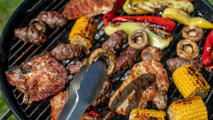 Barbecue grill with assorted meats and vegetables, perfect for summer gatherings, Fourth of July, and outdoor cooking celebrations