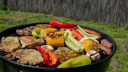 Grilled meats and vegetables on a charcoal barbecue for a festive summer cookout, perfect for Independence Day celebrations