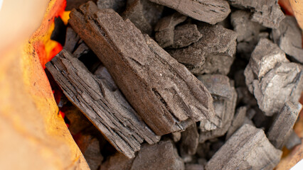 Charcoal burning in a grill, essential for barbecue cooking, summer outdoor gatherings, and holiday celebrations like Memorial Day