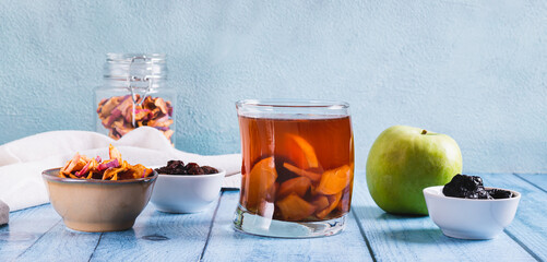 Traditional drink made from prunes, raisins and apples uzvar in a glass on the table web banner