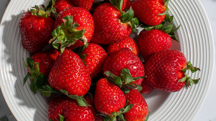 Fresh strawberries on white plate, symbolizing summer harvest, healthy eating, perfect for holiday desserts and festive treats