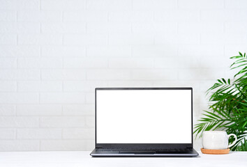 Fototapeta premium Laptop with white screen with tea cup on table