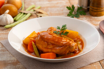 Asian style chicken stew in white plate.Slow cooked chicken,a rich and hearty mix of tender chicken and crispy skin smothered in gravy-like sauce.