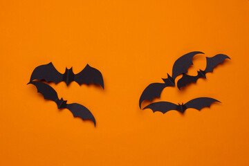 Paper cut black bats on orange background. Halloween decor
