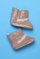 Baby's warm boots on blue background