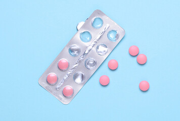 Pink tablets with blister on blue background