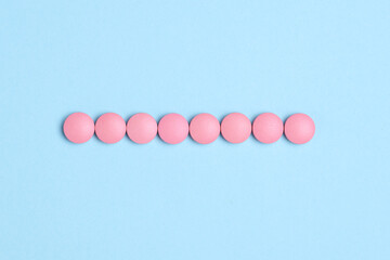 Pink pills on a blue background