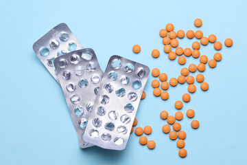 Orange pills with blisters on blue background