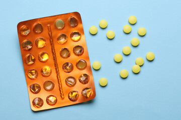 Yellow pills with orange blisters on blue background