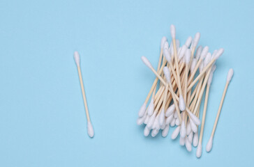 Cotton wooden sticks swabs for cleaning ears or makeup on blue background. Eco concept