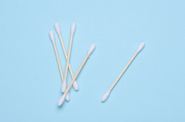 Cotton wooden sticks swabs for cleaning ears or makeup on blue background. Eco concept