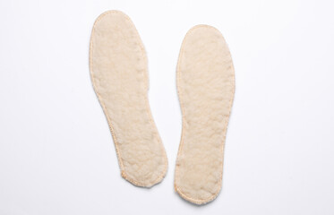 Pair of wool thermal insulating insoles on a white background