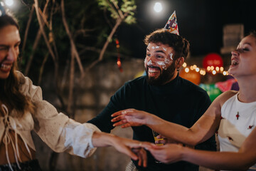 A group of friends enjoys a fun birthday celebration outdoors, sharing laughter and happiness.
