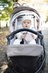 Little cute baby sitting in stroller outdoors