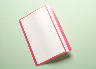 Plastic folder with paper sheets on green background. Business mockup