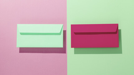 Pink and green envelopes on pastel background. Creative layout