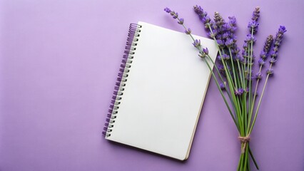 A blank notebook lies on a purple background, accompanied by a bouquet of fragrant lavender flowers.