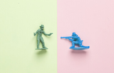 Plastic cowboys on pastel background. Wild west, western. Minimalism