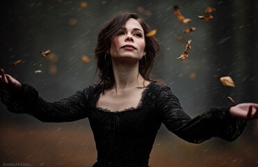 A woman in a black dress throwing leaves in the air