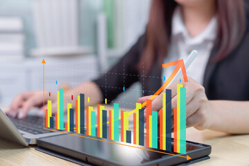 Businesswoman using laptop and tablet to analyze company growth, future business growth arrow graph, business trends, financial data for long term investment, development to achieve goals.