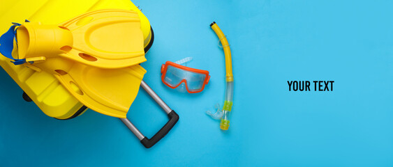 Beach vacation, summer holiday, relocation concept. Suitcase luggage with beach accessories: diving mask, flippers and snorkel on blue background. Space for your text © splitov27
