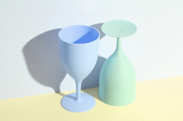 Creative layout with plastic colored glasses or goblets on a pastel background with a shadow. minimalism. Conceptual party concept