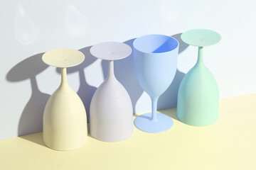 Creative layout with plastic colored glasses or goblets on a pastel background with a shadow. minimalism. Conceptual party concept