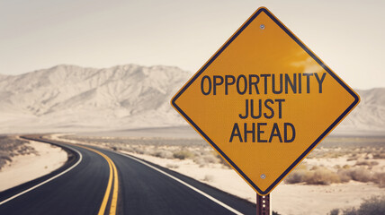 Yellow road sign on desert road, mountains in background, reads "Opportunity Just Ahead", symbolizing hope and progress on life journey