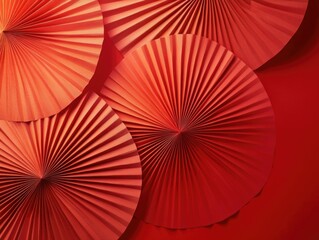 A collection of intricately designed red paper fans, arranged in a row and presented against a complementary red backdrop. The fans display a combination of radial and symmetrical patterns, adding an
