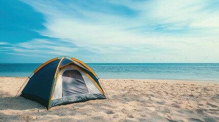 A tent pitched on a sandy beach with the ocean in the background