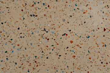 terrazzo floor texture featuring multi-colored marble chips embedded in neutral beige cement base