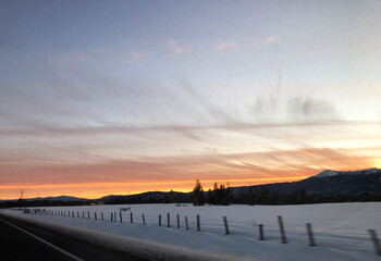 Obraz premium Sunset on the road from Brundage Mountain ski resort. View from car.