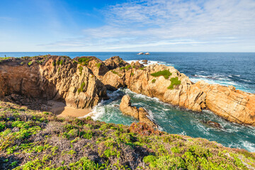 Stunning coastal landscape along California's Highway 1, featuring rugged rocky formations, and the vast blue ocean. A breathtaking natural scene showcasing the raw beauty of the Pacific coastline