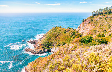 Stunning coastal landscape along California's Highway 1, featuring rugged rocky formations, and the vast blue ocean. A breathtaking natural scene showcasing the raw beauty of the Pacific coastline