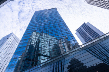 Modern skyscrapers with reflective glass facades under a blue sky. Urban architecture, business district, financial center, corporate growth, and city development