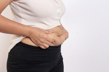 Overweight woman hand pinching excessive belly fat on gray background, Healthy concept