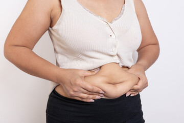 Overweight woman hand pinching excessive belly fat on gray background, Healthy concept