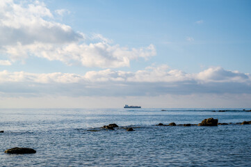 Adriatic sea in Albania, fishing boat on the horizon view from the beach.