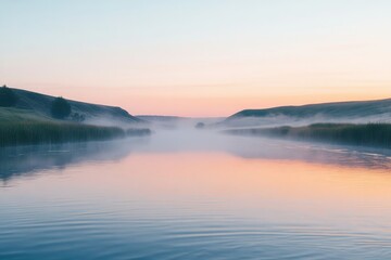 Fototapeta premium Serene sunrise over a misty river, calm water reflecting pastel sky.