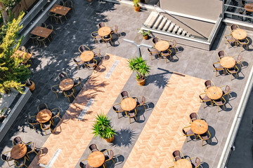 tables with chairs on outdoor cafe terrace, top view