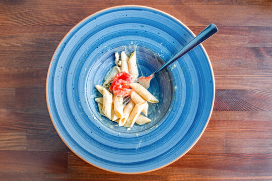 half-eaten penne pasta with cream sauce, top view