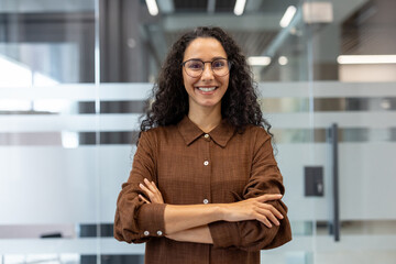 Portrait of successful joyful businesswoman at workplace inside office. Woman satisfied with...