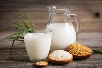 Rice milk in a glass on the wooden table.  Non dairy, plant based alternative milk, vegetarian,...